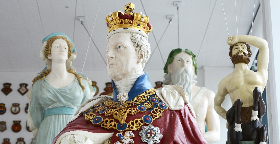Four ship figureheads suspended from the ceiling at the entrance of The Box